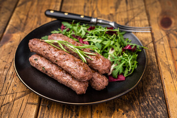 Balkan BBQ roast Cevapcici Sausage, roasted Cevapi from mince beef and pork meat. wooden background. top view
