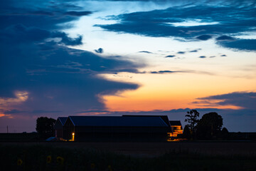 Fototapeta premium Scenic view of a farm which is silhouetted against the twilight sky