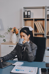Asian Businesswoman Using laptop computer and working at office with calculator document on desk,...