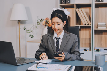 Portrait of a happy Asian businesswoman using mobile phone indoor, Asian businesswoman working in...