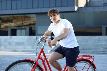 Teenage boy riding bicycle on city street