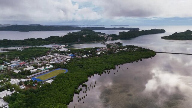 Aerial cinematic drone shot revealing a small island town by the shore of the islands of Palua