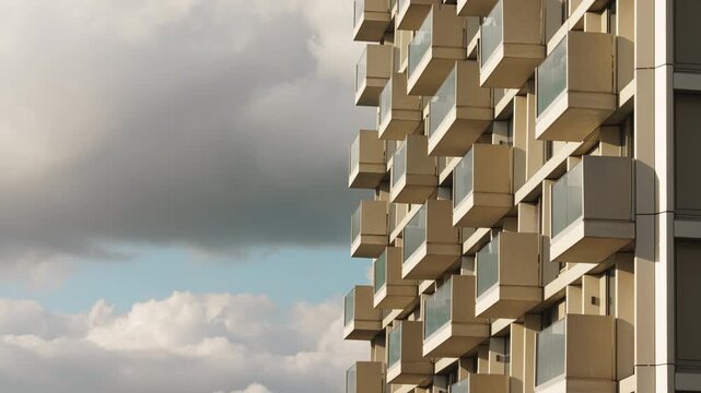 Residential tower with modular balconies and dramatic cloud motion in architectural timelapse