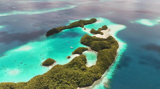 Captivating drone footage gliding around the electric-blue seas and untouched islands surrounding Palau. Wide cinematic aerial shot.