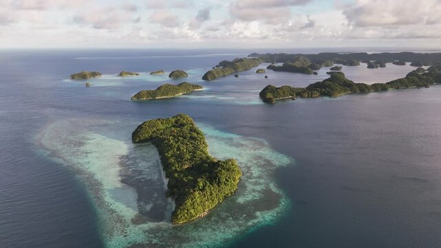 Captivating drone footage orbiting to expose the rich ocean blues and forested island clusters in Palau during the sunset. Cinematic epic aerial drone shot.