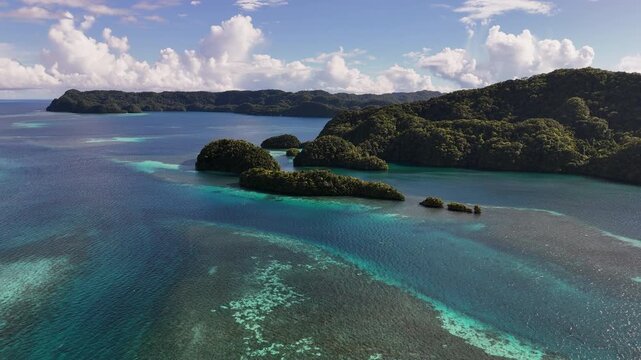 Epic aerial clip orbiting and revealing the electric-blue seas and untouched islands in Palau. Wide orbiting aerial drone shot.