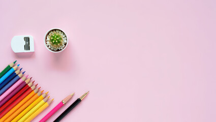 Naklejka premium Colorful Pencils and Cactus Flat Lay on Pink Backdrop A Creative Composition of Art Supplies with a Small Plant for Artistic Projects and Inspiration