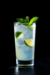 Refreshing mojito cocktail with lime and mint on a dark background