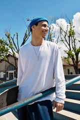 Young man enjoys a sunny day at the park while leaning on a skateboard