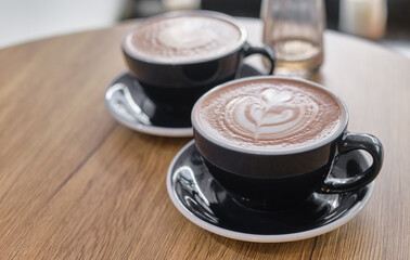 Cup of hot cacao with shape heart symbol of love, hot chocolate on a table. Shallow depth of field