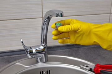 changing the faucet aerator in a mettallic kitchen sink