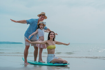 Family on a tropical beach vacation hold playing with an inflatable rubber ring. A beautiful family...