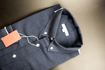 A dark blue folded men shirt with a red sale tag. Fashion and shopping concept