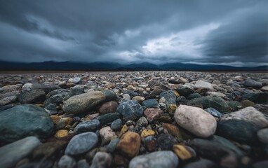 Fototapeta premium Boulder field of rocks and gravel on a beach under an overcast sky with soft contrast look