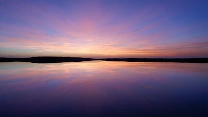 Obraz premium Serene Sunset Reflection Over Calm Lake Water
