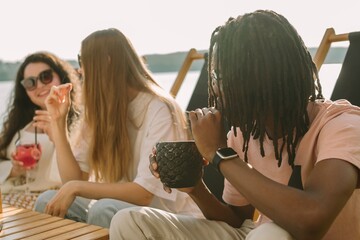 Friends enjoying drinks and conversation at a lakeside cafe