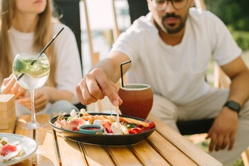 Friends enjoying appetizers and drinks at outdoor cafe