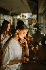 Young woman using smartphone in a cafe with friends
