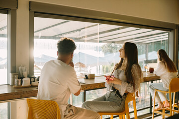 Friends enjoying drinks and conversation in a sunny cafe