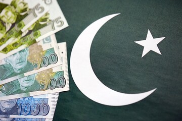 Pakistan rupees banknotes on Pakistani flag background. The current Pakistan money bills
