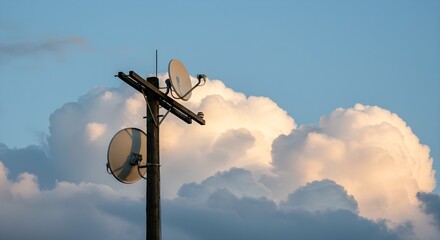 Two satellite dish on pole with cumulus clouds in background. Modern telecommunication technology with television antenna.