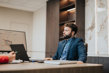 A business professional engaged in a discussion while sitting in a modern office with analytical...