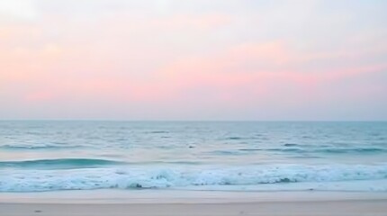 Obraz premium Soft Pink Sunset Over Calm Ocean Waves on Sandy Beach