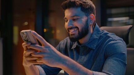 Indian ethnic businessman man business guy in evening office late night addict using mobile phone...