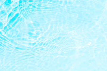 Obraz premium Blue water with ripples on the surface. Defocus blurred transparent blue colored clear calm water surface texture with splashes and bubbles. Water waves with shining pattern texture background.