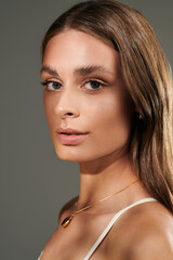 Natural summer beauty of young woman with tan skin glowing in studio setting