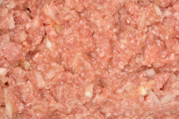 A close-up, textured view of the raw mixture for stuffed peppers, featuring ground meat, finely chopped onions, rice, and hints of egg