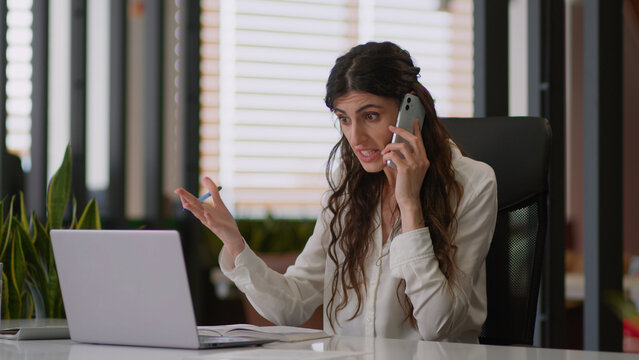 Caucasian girl busy annoyed businesswoman female lady angry office manager multitasking business woman talk mobile phone online work laptop write tasks notebook cellphone call argue conflict problem