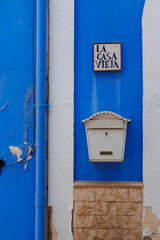 A charming blue and white wall featuring the sign 'La Casa Vieja' and a vintage mailbox. This scene captures the essence of coastal Alicante architecture and culture.