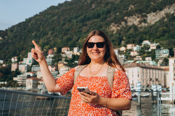 Happy brunette 30s woman enjoying summer holidays. Concept of vacation and travelling, Italy. Lake...
