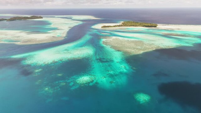 Sweeping drone shot panning and orbiting to highlight the radiant blue waters and wild island landscapes of Palau. wide revealing orbiting shot.