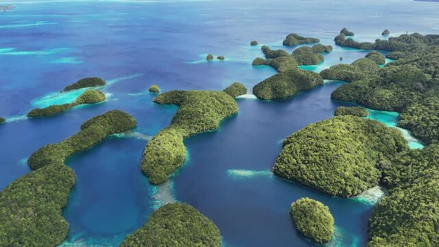Stunning drone orbiting wide shot to expose the serene turquoise coastline and small tropical islands around Palau. Wide circlings revealing drone shot.