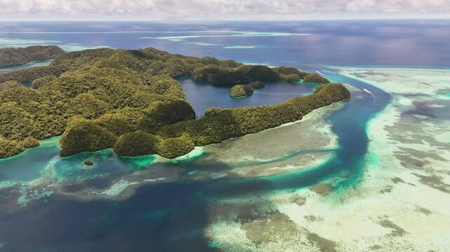 Sweeping drone shot scanning and revealing the pristine turquoise sea and lush islets in Palau. wide revealing aerial shot.