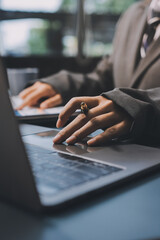 Close up of business woman hands typing on laptop computer and digital tablet, searching and...
