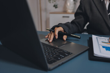 Close up of business woman hands typing on laptop computer and digital tablet, searching and...