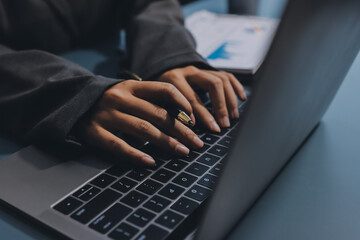 Close up of business woman hands typing on laptop computer and digital tablet, searching and...