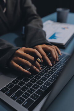 Close up of business woman hands typing on laptop computer and digital tablet, searching and surfing the internet on office desk, online working, telecommuting, freelancer at work concept