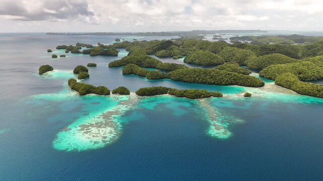Dynamic drone shot revealing the vibrant blue ocean and scenic islands near Palau. wide revealing drone shot.