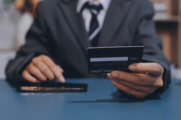 Online payment,businessman hands holding credit card and using  laptop for online shopping. Cyber...