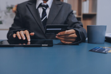 Online payment,businessman hands holding credit card and using  laptop for online shopping. Cyber...