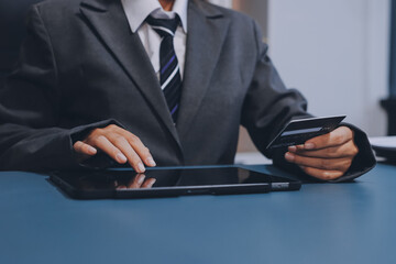 Online payment,businessman hands holding credit card and using  laptop for online shopping. Cyber...