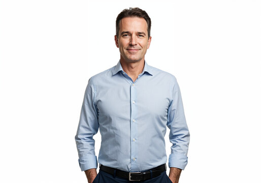 A smiling middle aged man in a light blue button down shirt and dark pants stands with hands in pockets