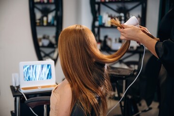 Examining the health of hair. Woman is in a beauty salon with hair stylist