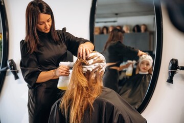 Washing the head. Woman is in a beauty salon with hair stylist