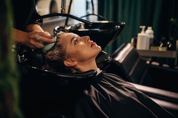 Massaging the skin on head. Woman is in a beauty salon with hair stylist