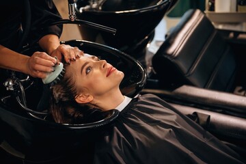 Healthy massage for the head and skin. Woman is in a beauty salon with hair stylist